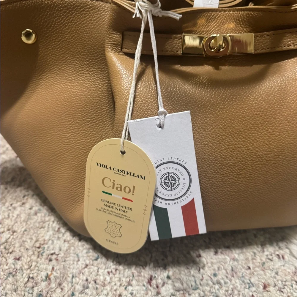 Viola Castellani. Tan leather tote bag with gold hardware. Adjustable strap.